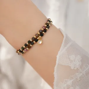 Close-up of 18k gold plated double-layer beaded bracelet with sparkling zircon pendant