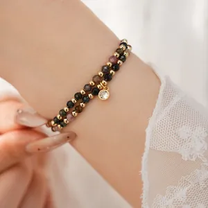 Detail view of 18k gold plated double-layered beaded bracelet with zircon charm