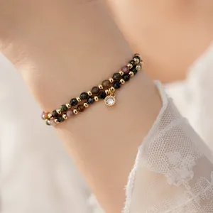Close-up of double-layer beaded bracelet with 18k gold beads and colorful stones