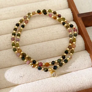 Close-up of 18k gold-plated double-layer bracelet with colorful beads and CZ charm.