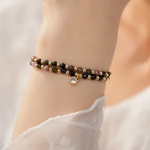 Detailed view of 18k gold plated double-layer beaded bracelet with zircon charm