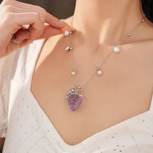 Gros plan détaillé d'un collier avec fraise en résine violette et perles sur modèle