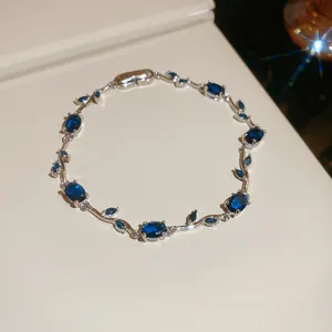 Exquisite detail view of a silver vine-style bracelet featuring oval and marquise blue stones