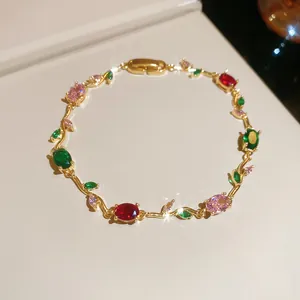 Detailed view of a gold-tone vine bracelet set with colorful oval gemstones