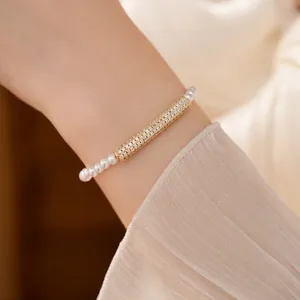 Elegant pearl bracelet with gold zircon-inlaid bar on model wrist