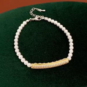 Detail view of an elegant white pearl bracelet with a sparkling gold zircon-inlaid bar.