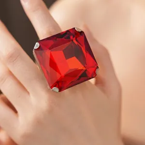 Elegant large square cut red gemstone cocktail ring with silver prongs on model finger