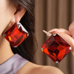 Detailed view of oversized red square crystal earrings with luxury multifaceted design