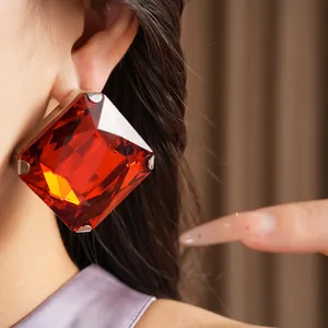 Close-up of a large bold square red gemstone earring with luxury silver finish