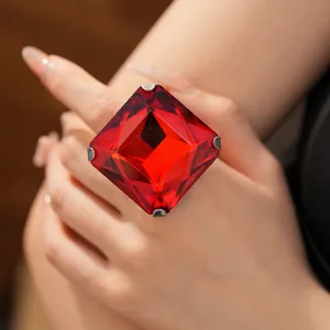 Detailed close-up view of a large square faceted red gemstone ring worn on a hand