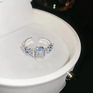 Detailed shot of an adjustable silver ring with square blue and white zircons