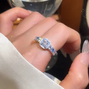 Elegant close-up of a luxury square zircon ring with blue side stones on a model's finger