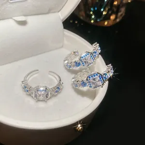 Close-up of silver-tone jewelry set with square zircons and blue accents