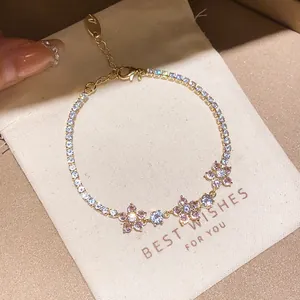 Vue détaillée d'un élégant bracelet en or orné de fleurs en zircon rose sur une pochette
