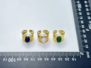Detail shot of three vintage gold rings with natural stones on a measurement scale