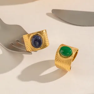 Close-up detail of vintage stainless steel gold ring with oval blue and green stones.