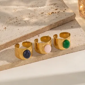 Detail of vintage 18K gold plated stainless steel rings with oval natural stones