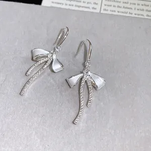 Elegant silver-colored bow earrings with sparkling cubic zirconia and white enamel details.
