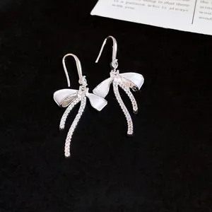 Elegant silver bow drop earrings with white enamel and sparkling cubic zirconia