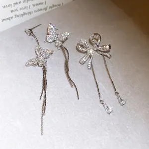 Elegant asymmetrical silver needle earrings with zirconia butterfly and bow motifs