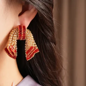 Primo piano dettagliato di orecchini a fiocco con strass rossi e trasparenti stile vintage