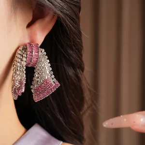 Primo piano dettagliato di orecchini vintage a fiocco in argento con pietre di zircone rosa