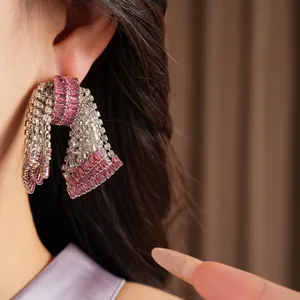 Primo piano di eleganti orecchini vintage a fiocco con zirconi rosa e bianchi pregiati