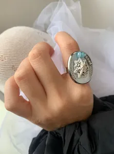 Detailed view of ocean-inspired adjustable ring with seashell motif and blue beads