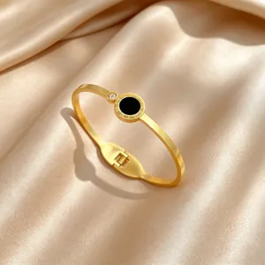 Detailed shot of gold titanium steel bangle with Roman numerals and black inlay