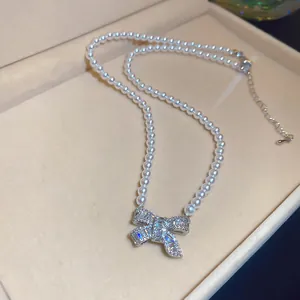 Detail of zircon bow pendant on elegant white pearl necklace for women