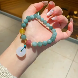 Hand-held round chalcedony beaded bracelet featuring a white jade donut pendant