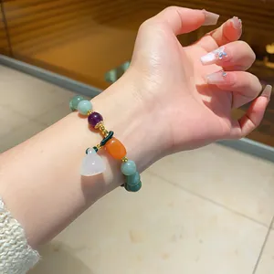 Exquisite colorful chalcedony beaded bracelet with a lotus pod charm worn on a wrist