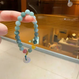 Elegant chalcedony beaded bracelet with colorful accents and a jade donut pendant