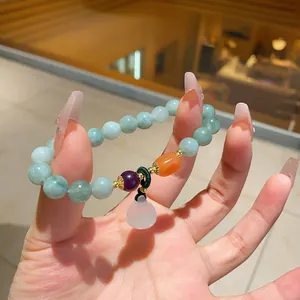Detailed macro view of elegant chalcedony beaded bracelet with light green and orange accents