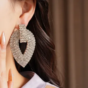 Primo piano di orecchini a goccia con strass scintillanti per donna elegante