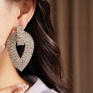 Dettaglio ravvicinato di orecchini a goccia di lusso con strass sull'orecchio di una modella