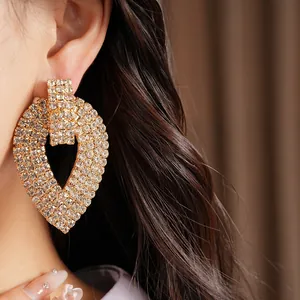Dettaglio di lussuosi orecchini a cuore con strass indossati da una modella