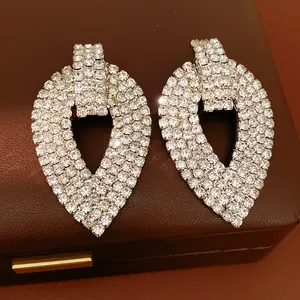 Primo piano di orecchini a goccia color argento pavimentati con strass scintillanti