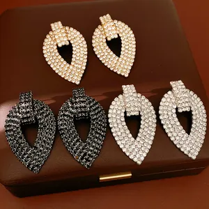 Macro di orecchini a goccia con strass nei colori oro nero e argento