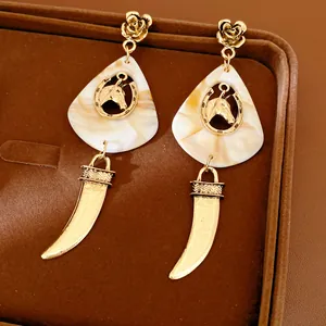 Detailansicht der Vintage-Resin-Pferdeohrringe mit goldenen Akzenten in Schmuckschatulle