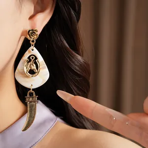 Detailansicht von Vintage-Harzohrring mit Pferdekopf-Motiv und goldenem Hornanhänger