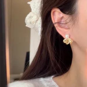 Close-up of elegant 18K gold plated pearl earrings with zircon bow detail on ear