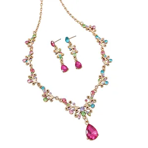 Set di gioielli vintage dorati con strass colorati e grandi pendenti a goccia rosa