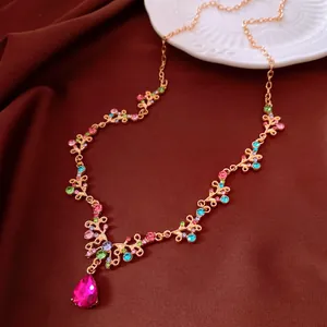 Collana vintage con strass multicolori e ciondolo in cristallo a goccia rosa acceso.