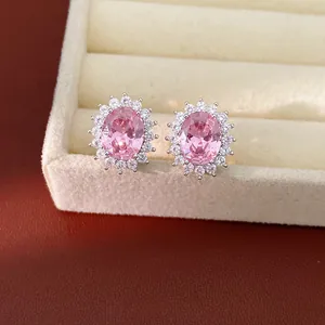 Detailed macro view of elegant silver-tone stud earrings with oval pink zircon and crystal halo