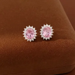 Close-up view of elegant oval pink zircon stud earrings featuring a clear crystal halo