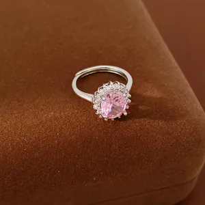 Close-up detail of an elegant silver ring with a large pink oval zircon halo setting