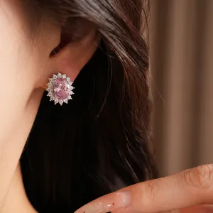 Detailed view of elegant pink oval zircon stud earring with halo stones on ear
