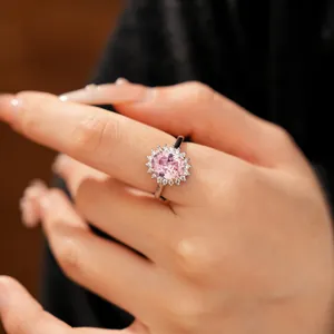Close-up detail of silver ring with oval pink zircon and halo of small clear stones