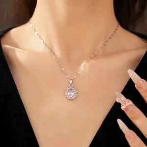 Detail shot of a minimalist silver necklace with an oval pink zircon pendant on a model.